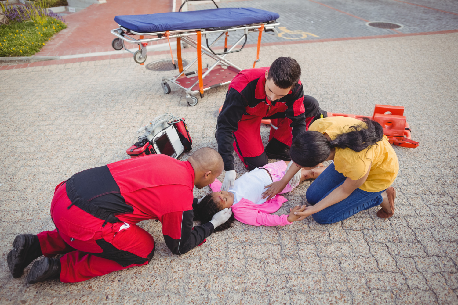 A child being treated by emergency medical staff in red uniforms